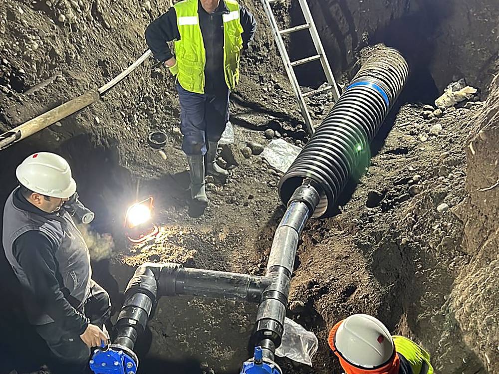 Cuadrilla resolviendo la unión de una matriz sanitaria en terreno