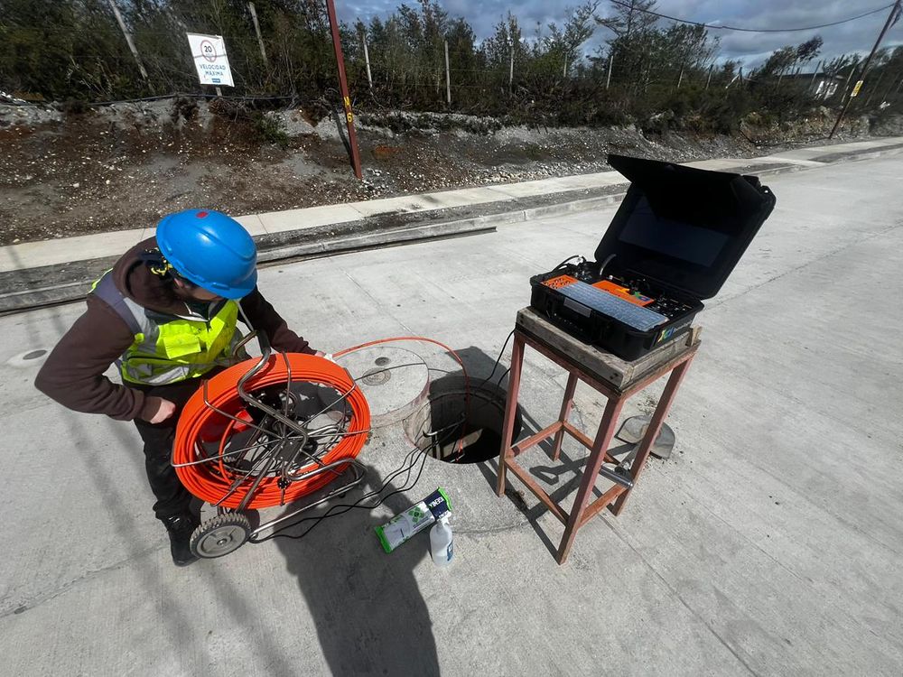 Equipo de inspección televisiva operando una cámara en una cámara de alcantarillado